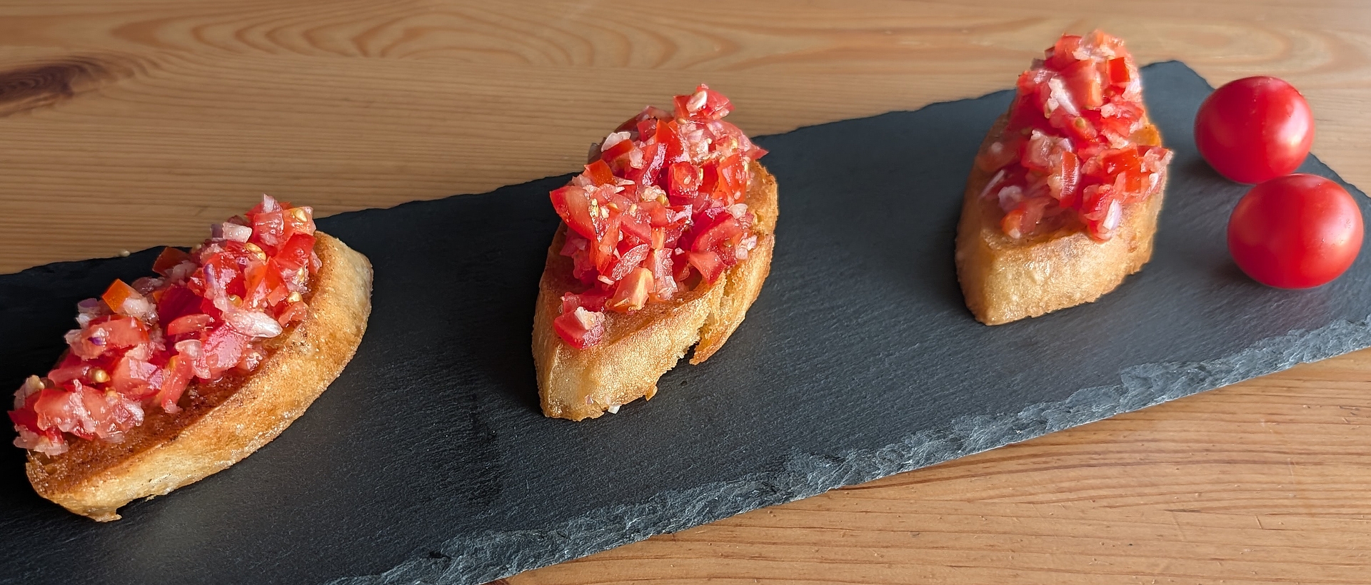 Drei Bruschetta auf einer Schieferplatte